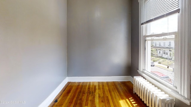 unfurnished room with hardwood / wood-style floors and radiator