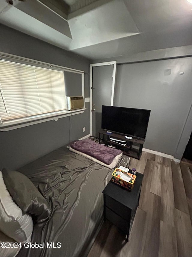 bedroom with hardwood / wood-style floors and cooling unit