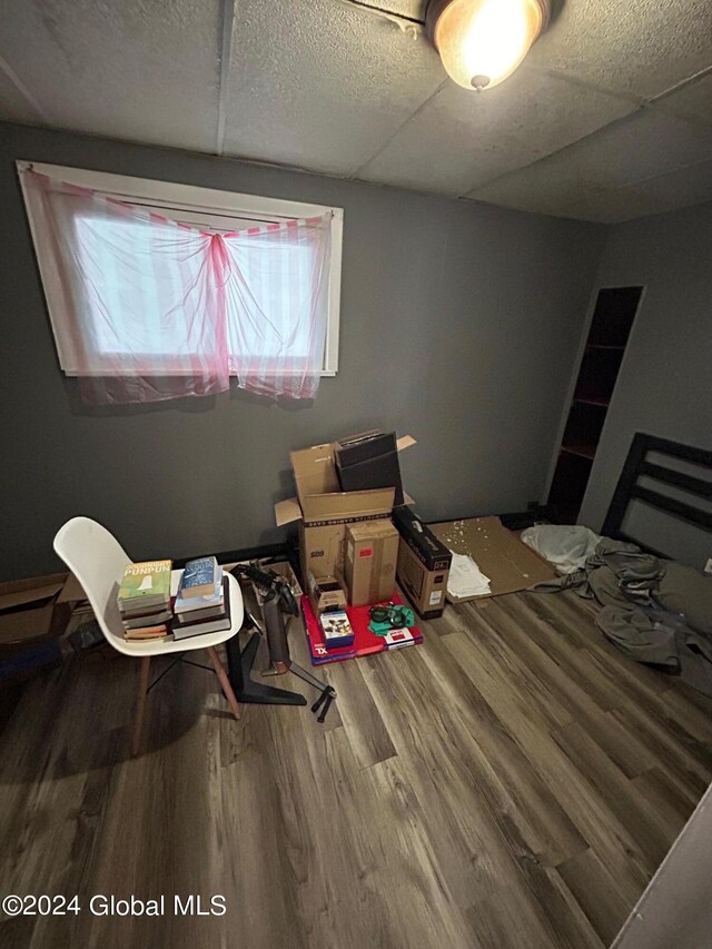 bedroom featuring hardwood / wood-style flooring and a drop ceiling