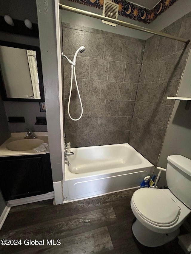 full bathroom featuring toilet, hardwood / wood-style floors, vanity, and tiled shower / bath