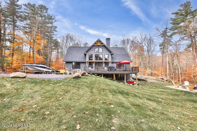 back of house featuring a lawn and a deck