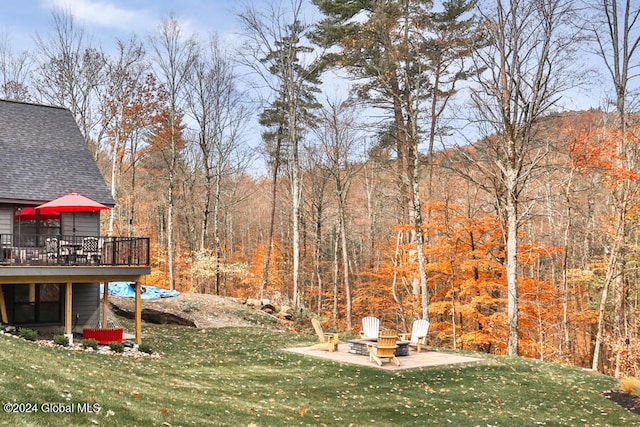 view of yard with a deck, an outdoor fire pit, and a patio