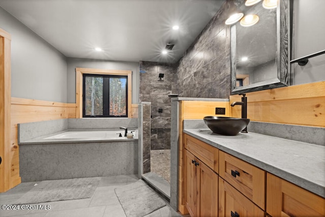 bathroom featuring tile patterned flooring, vanity, and shower with separate bathtub