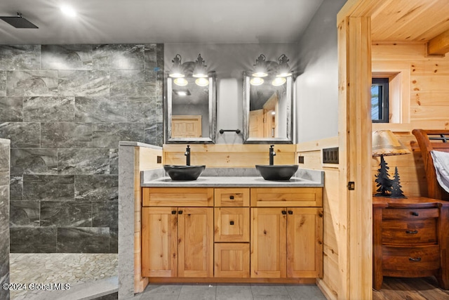 bathroom with wood walls, vanity, and walk in shower