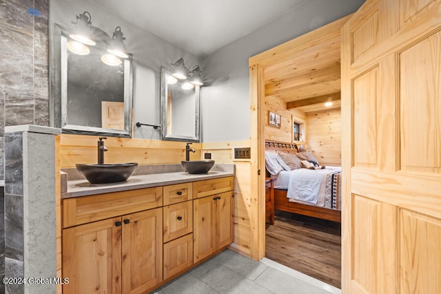 bathroom with tile patterned flooring, vanity, and beamed ceiling