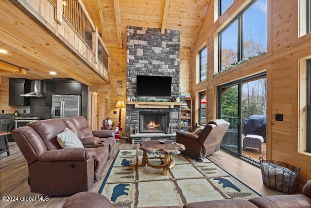 living room featuring high vaulted ceiling, wood walls, a fireplace, wood ceiling, and hardwood / wood-style flooring