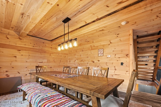 dining space featuring beam ceiling, wooden ceiling, and wood walls