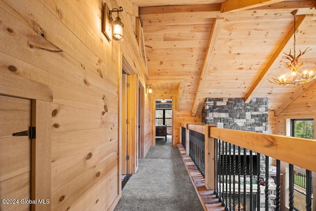 corridor featuring dark colored carpet, vaulted ceiling with beams, wood ceiling, and wood walls