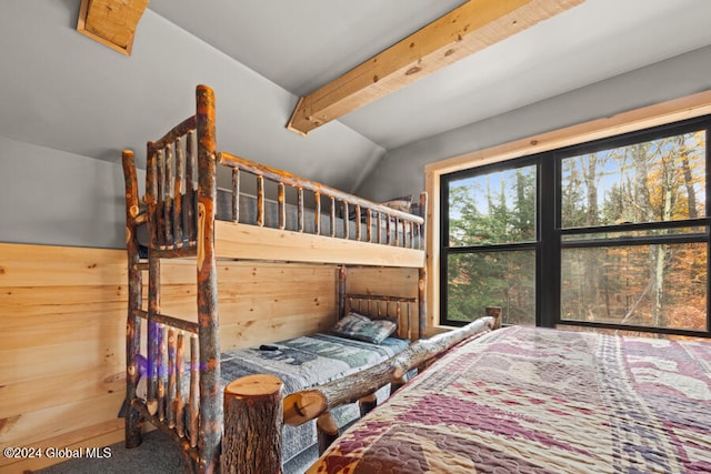 bedroom featuring lofted ceiling with beams, carpet floors, and wooden walls