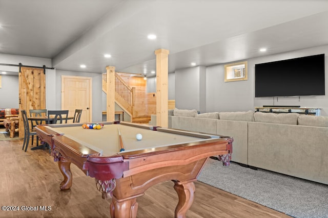 game room with a barn door, pool table, and light hardwood / wood-style flooring