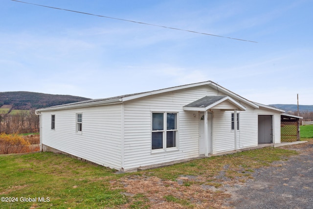 view of front of home with a front yard and a carport