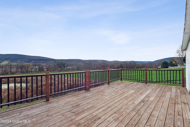 wooden terrace featuring a mountain view and a lawn