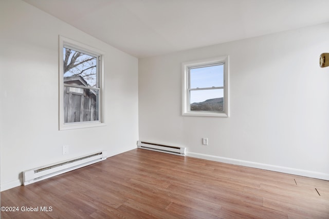 unfurnished room featuring light hardwood / wood-style floors and baseboard heating