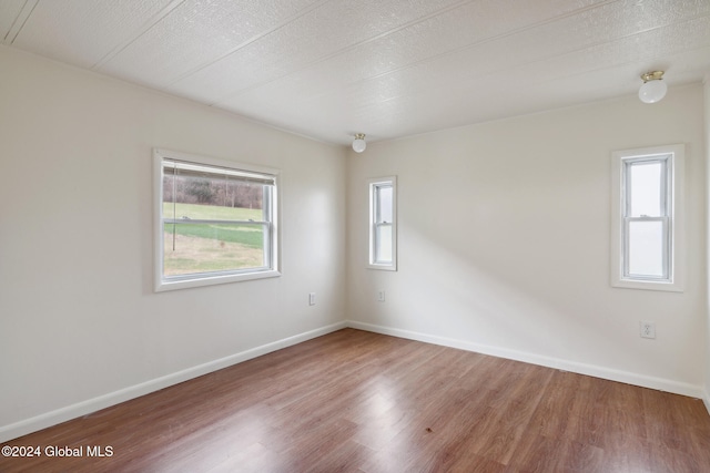 spare room with a textured ceiling and hardwood / wood-style flooring