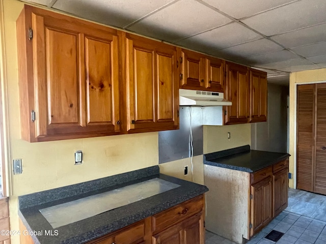 kitchen featuring a drop ceiling and light tile patterned floors