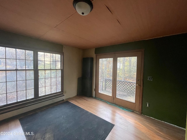 interior space with hardwood / wood-style flooring, baseboard heating, and plenty of natural light