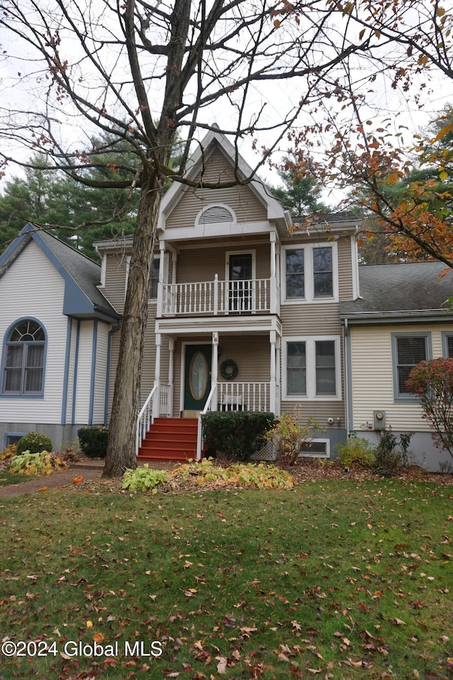 view of front of home featuring a front yard and a balcony