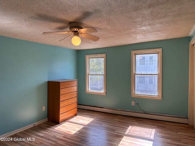 unfurnished room featuring baseboard heating, a textured ceiling, hardwood / wood-style flooring, and ceiling fan