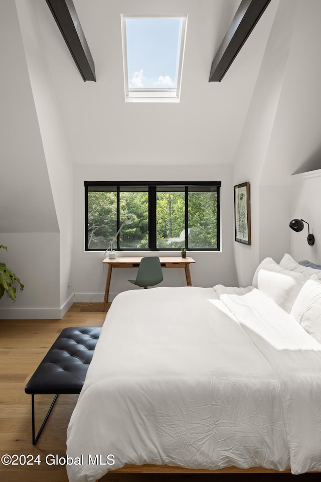 bedroom featuring light hardwood / wood-style flooring, lofted ceiling, and multiple windows