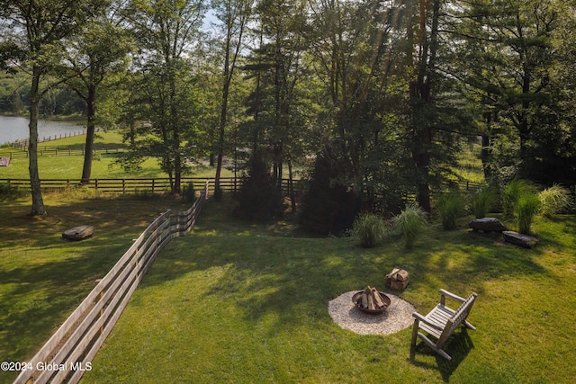 view of yard featuring a water view and a fire pit