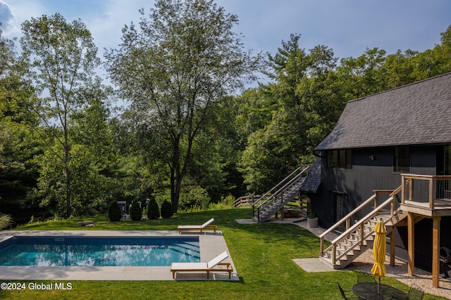 view of pool featuring a patio and a yard