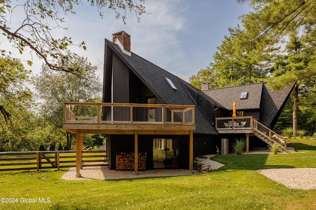 back of property with a wooden deck and a lawn