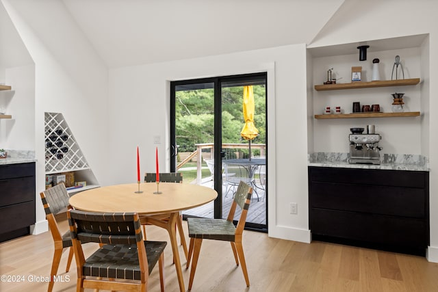 dining room featuring light wood-type flooring and lofted ceiling