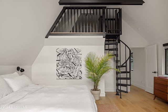 bedroom featuring light wood-type flooring and vaulted ceiling