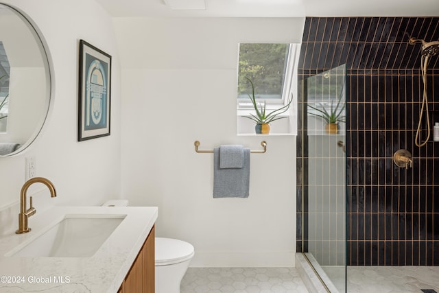 bathroom with toilet, vanity, and a tile shower