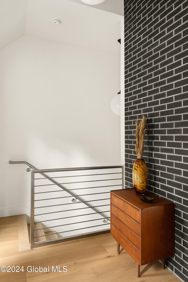 interior space with light hardwood / wood-style floors and brick wall