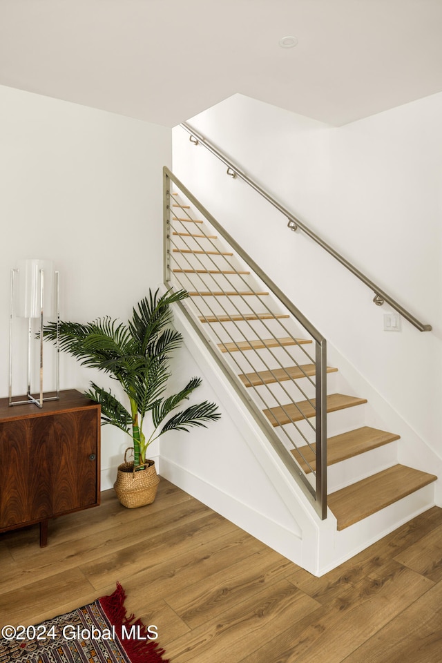 staircase with hardwood / wood-style flooring