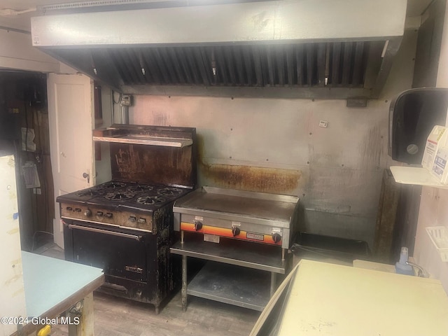 kitchen with high end black range, wood-type flooring, and extractor fan