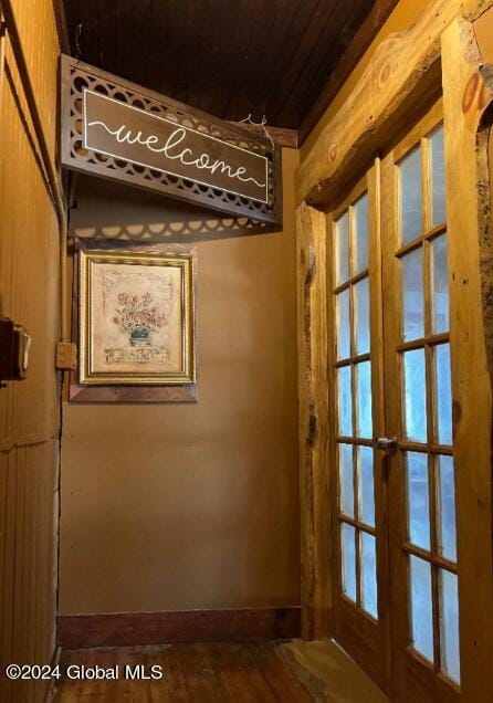 interior space with wooden ceiling, wooden walls, and french doors