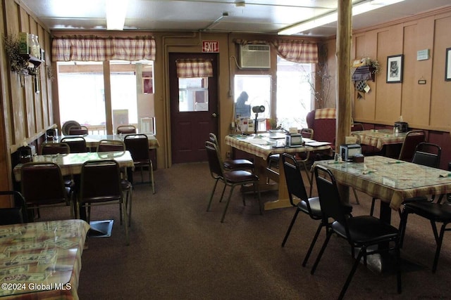 carpeted dining room featuring a wall mounted AC and a healthy amount of sunlight