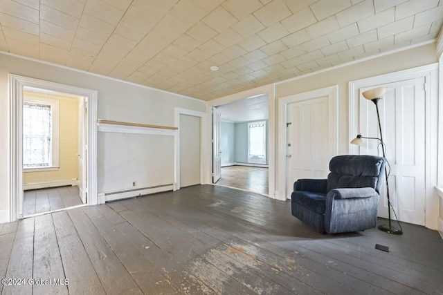 unfurnished room featuring ornamental molding, dark hardwood / wood-style flooring, and a baseboard heating unit