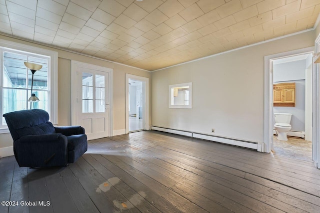 unfurnished room featuring hardwood / wood-style floors, crown molding, and a baseboard heating unit