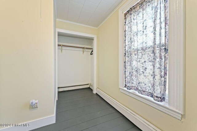 interior space with crown molding, hardwood / wood-style floors, and a baseboard heating unit