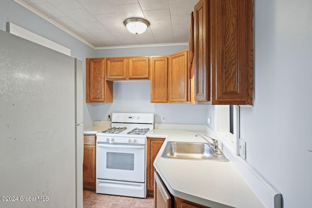 kitchen with crown molding, sink, and white appliances