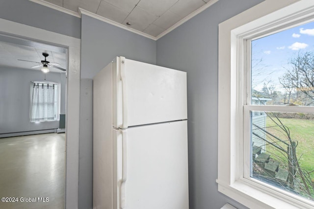 kitchen with a wealth of natural light, crown molding, a baseboard heating unit, and white refrigerator