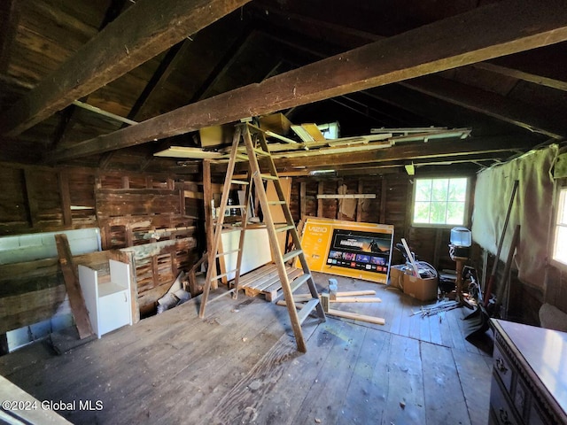 misc room featuring vaulted ceiling with beams, wooden walls, and wood-type flooring