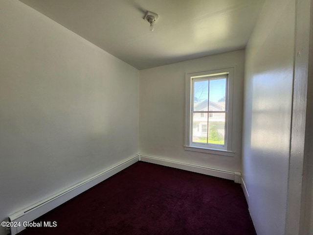 spare room featuring carpet floors and a baseboard heating unit