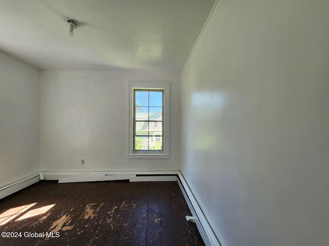 spare room with dark hardwood / wood-style flooring, crown molding, and a baseboard heating unit