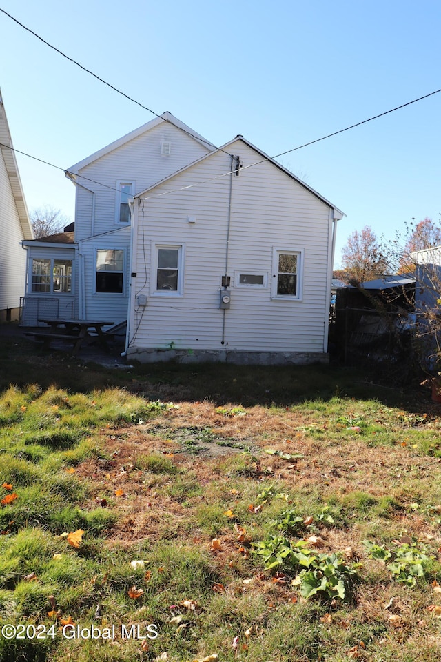 rear view of property with a lawn