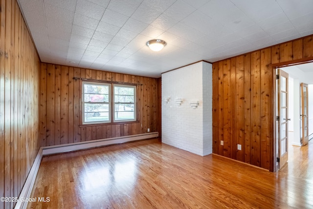 1258 Hawthorn Rd, Niskayuna, NY 12309 - spare room featuring wood finished floors, wood walls, baseboards, and a baseboard heating unit