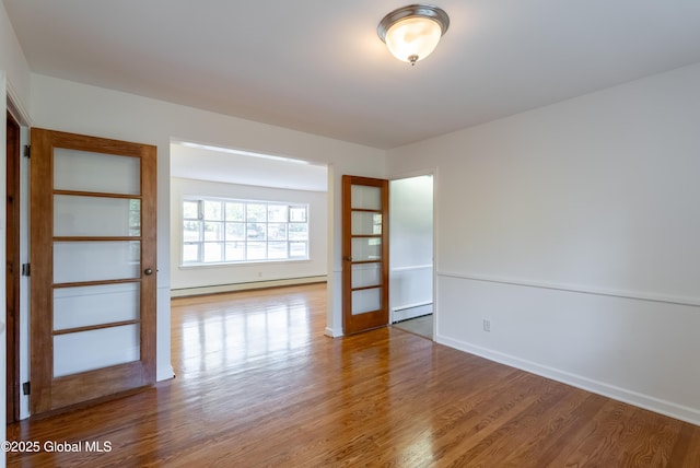 1258 Hawthorn Rd, Niskayuna, NY 12309 - spare room featuring a baseboard heating unit, wood finished floors, and baseboards
