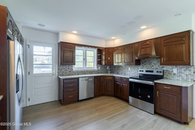 1258 Hawthorn Rd, Niskayuna, NY 12309 - kitchen with appliances with stainless steel finishes, premium range hood, backsplash, a sink, and light wood finished floors