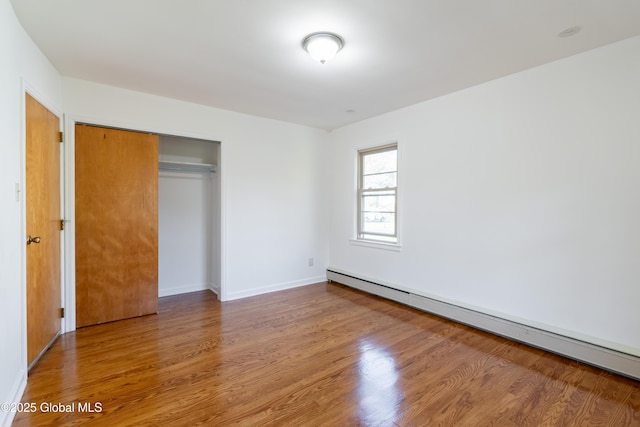 1258 Hawthorn Rd, Niskayuna, NY 12309 - unfurnished bedroom with baseboard heating, wood finished floors, a closet, and baseboards