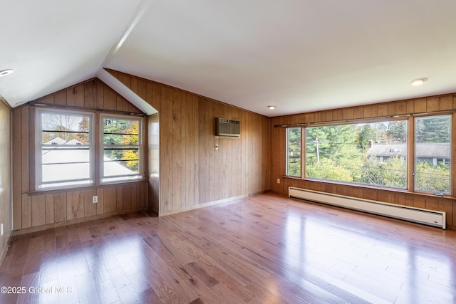 1258 Hawthorn Rd, Niskayuna, NY 12309 - spare room with a baseboard heating unit, wood finished floors, wood walls, vaulted ceiling, and baseboards