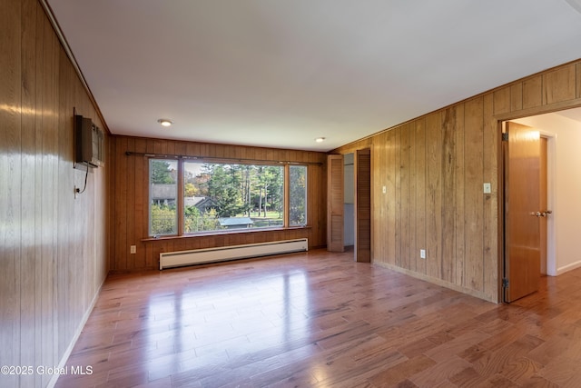 1258 Hawthorn Rd, Niskayuna, NY 12309 - empty room with a baseboard radiator, wooden walls, wood finished floors, and baseboards