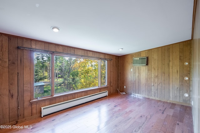 1258 Hawthorn Rd, Niskayuna, NY 12309 - unfurnished room featuring baseboard heating, wood finished floors, wood walls, an AC wall unit, and baseboards
